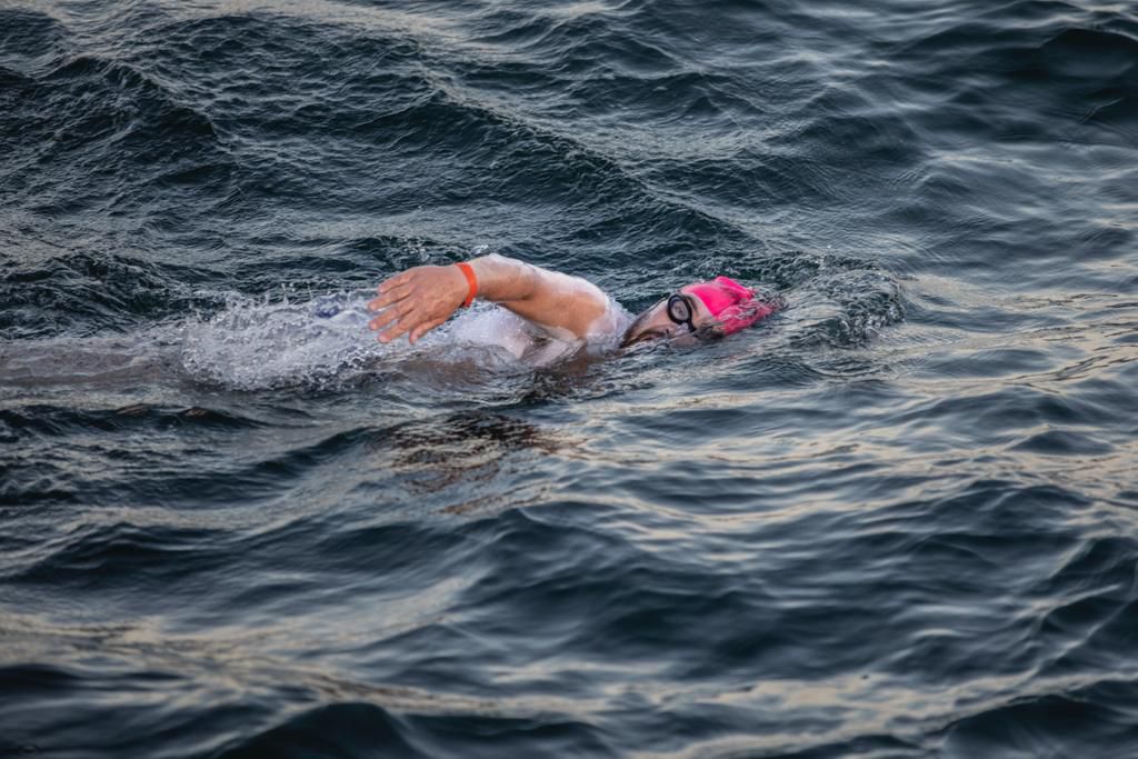 Antonio Argüelles nadando en mar abierto con gorra rosa